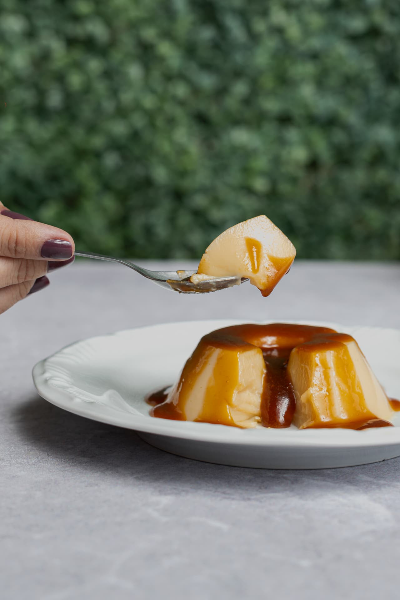 Pudim com calda de caramelo sendo servido em uma colher
